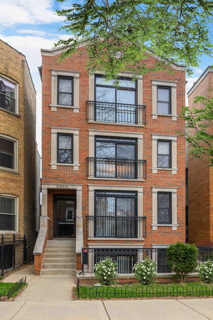 Front view of a multi-story brick building with balconies.