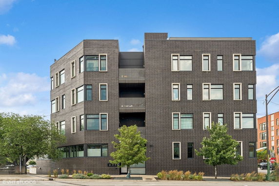 Front view of a modern multi-story brick building with numerous windows.