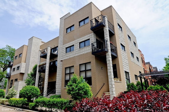 Front view of a multi-story apartment building with balconies.