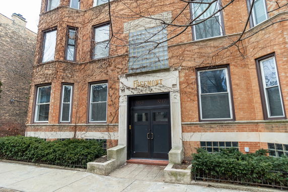 Front view of a brick apartment building with an entrance labeled 'FREEMONT'.
