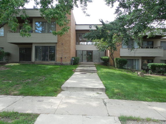 Front view of a multi-story apartment building with balconies.