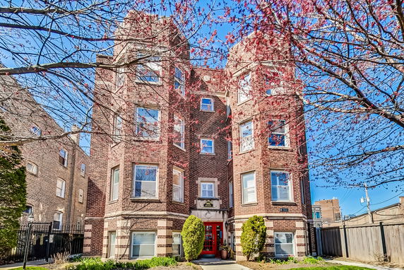 Front view of a multi-story brick apartment building.