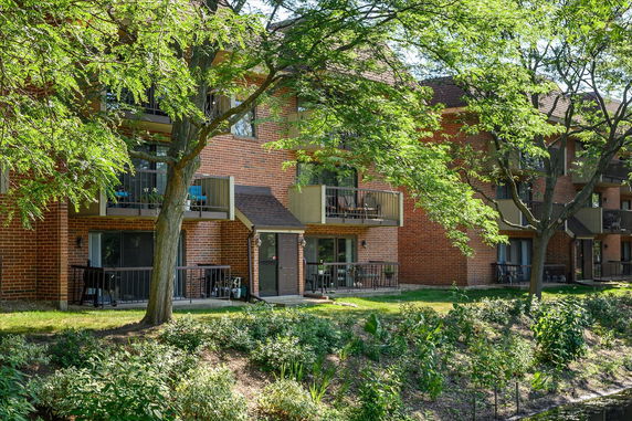 View of a multi-story brick apartment building with balconies.