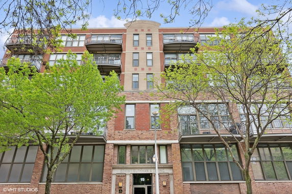 Front view of a multi-story brick building with balconies.