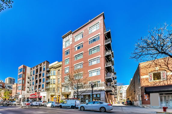 Front view of a multi-story apartment building on a city street.