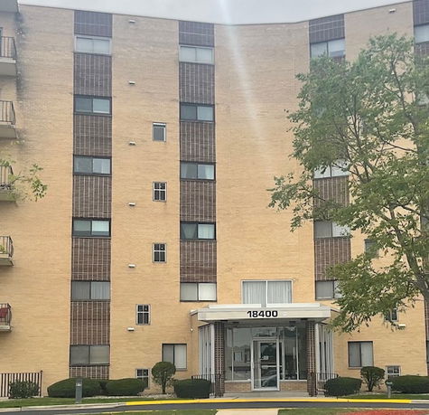 Front view of a multi-story residential building with a central entrance.