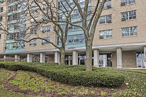 Front view of a multi-story building with large windows and a central entrance.