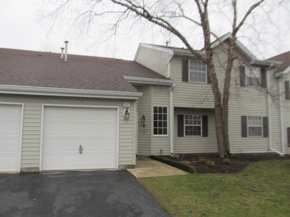 Front view of a two-story house with an attached single-car garage.