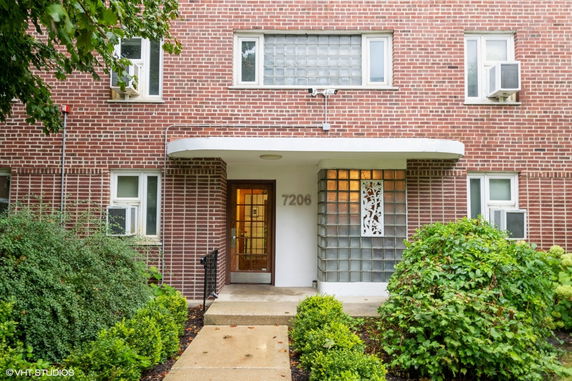 Front view of a brick building entrance with windows and glass blocks.