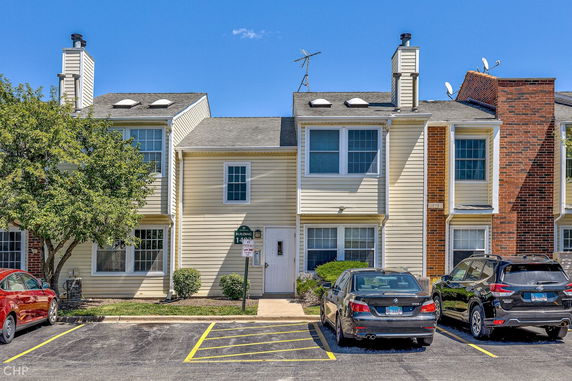 Front view of a multi-story residential building with parking spaces.