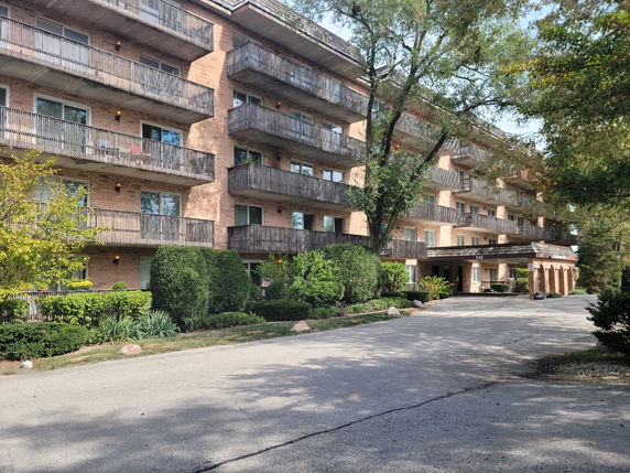 Front view of a multi-story apartment building with multiple balconies.