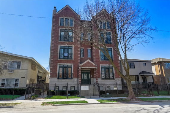 Front view of a four-story brick apartment building.