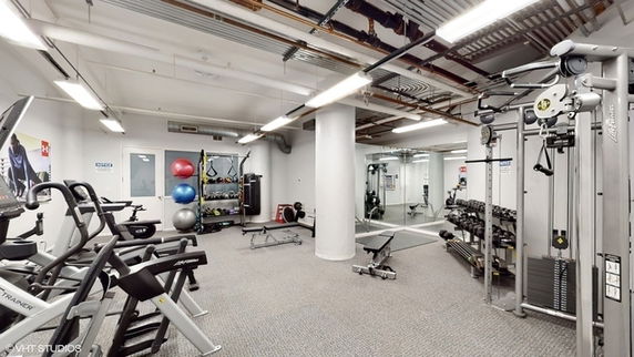 Indoor gym area with exercise equipment and mirrors.