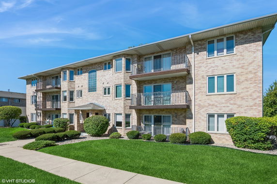 Front view of a three-story apartment building with balconies.