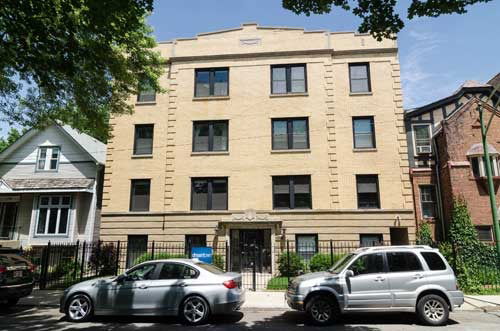 Front view of a multi-story brick building with multiple windows.