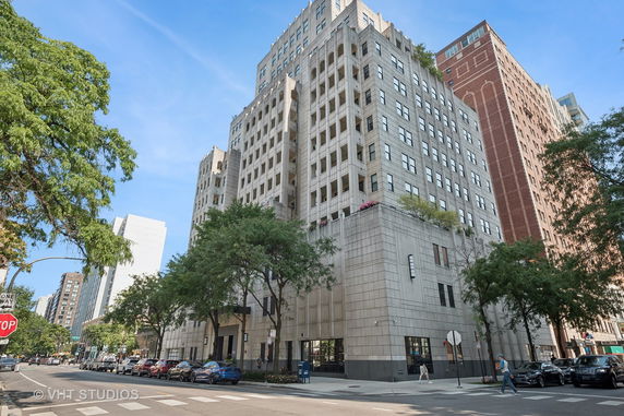 Front view of a multi-story building with an intricate facade in an urban setting.