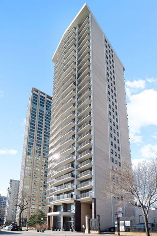 Front view of a tall apartment building with multiple balconies.