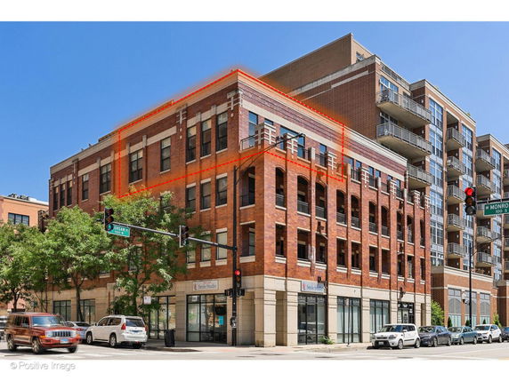 Front view of a multi-story brick building with large windows and balconies.