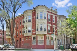Front view of a three-story brick building with bay windows.
