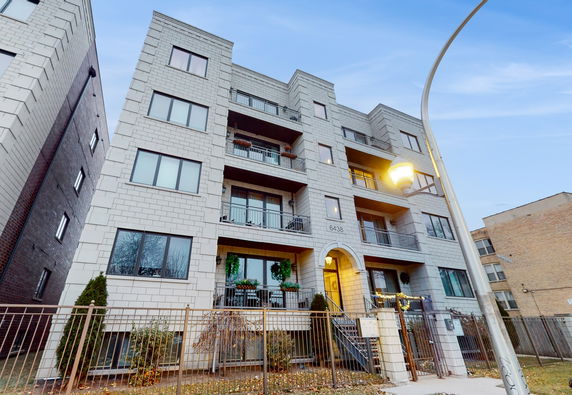 Front view of a multi-story apartment building with balconies.