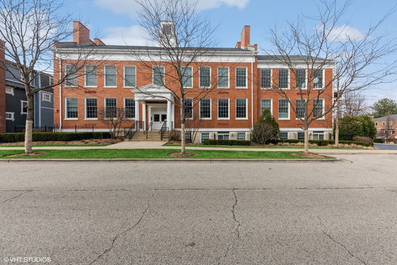 Front view of a large two-story brick building with a classic entrance.