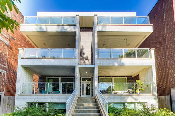 Front view of a multi-story apartment building with balconies.