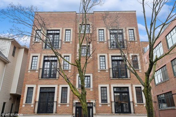 Front view of a multi-story brick building with multiple windows.
