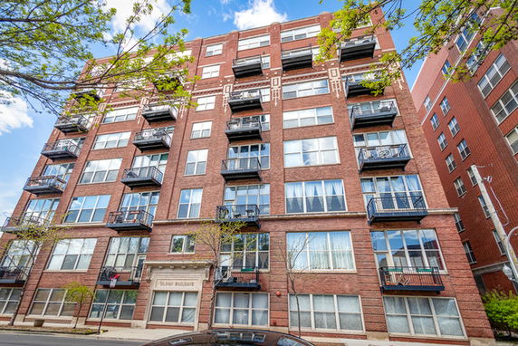Front view of a multi-story apartment building with balconies.