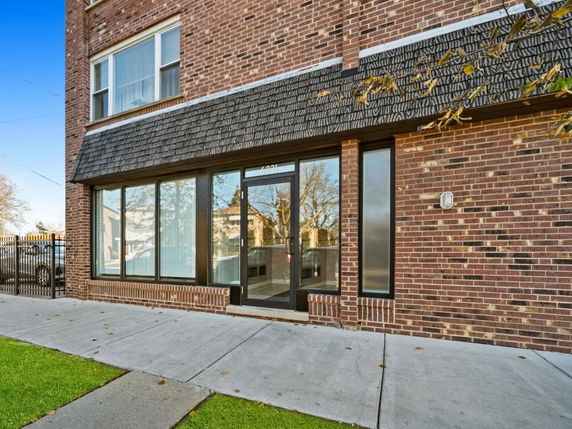 Front view of a brick building with large windows and a glass door.