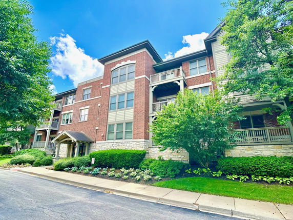 Front view of a multi-story apartment building with brick and stone facade.