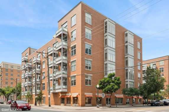 View of a multi-story brick apartment building with balconies.