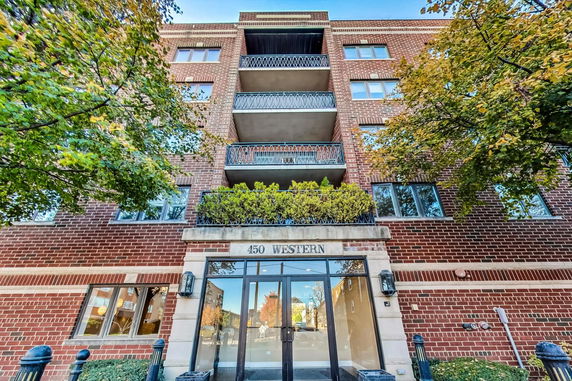 Front view of a multi-story brick building with balconies.