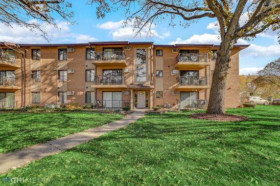 Front view of a three-story apartment building with multiple balconies.