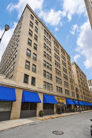 Front view of a multi-story building with blue awnings.