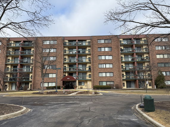 Front view of a multi-story apartment building with balconies.