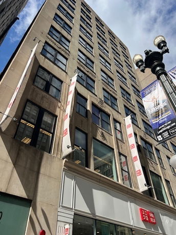 Front view of a multi-story commercial building with large windows and vertical banners.