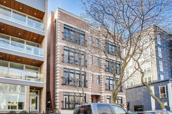 Front view of a multi-story residential building with brick facade.
