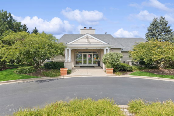 Front view of a house with a covered entrance and surrounding greenery.