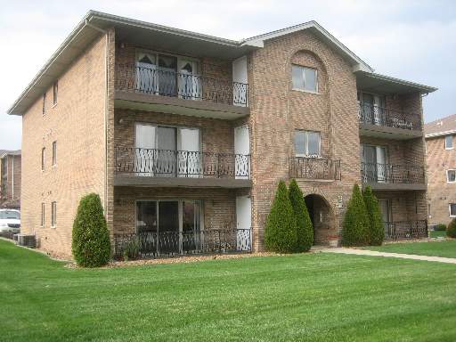 Front view of a three-story brick apartment building.