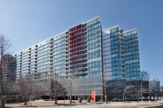 Front view of a modern high-rise building with large glass windows and red accents.
