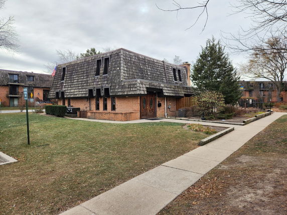 Front view of a two-story building with a unique slanted roof design.