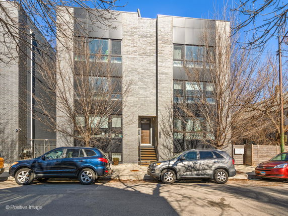 Front view of a modern multi-story building with a brick and metal facade.