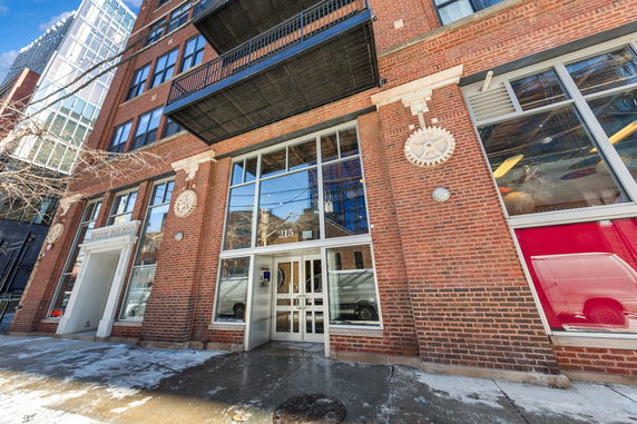 Front view of a multi-story brick building with large windows and a main entrance.