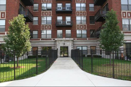 Front view of a multi-story brick apartment building with balconies.