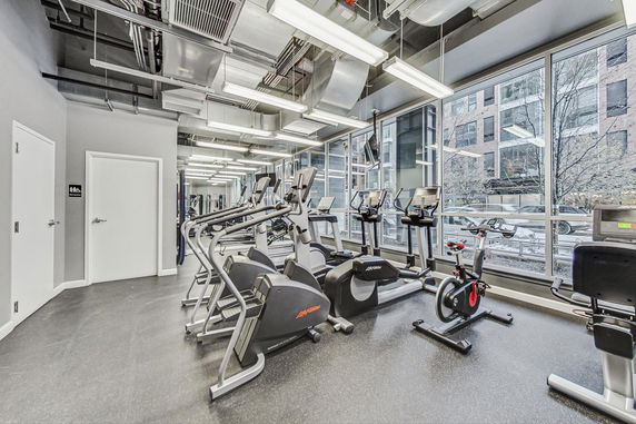 Interior view of a gym with various exercise equipment including treadmills and stationary bikes.