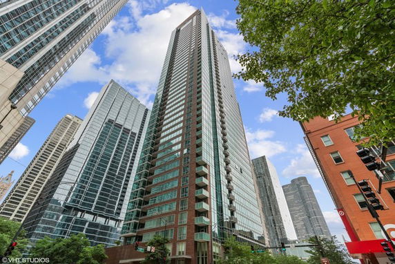 Front view of a tall modern skyscraper with glass and brick facade.