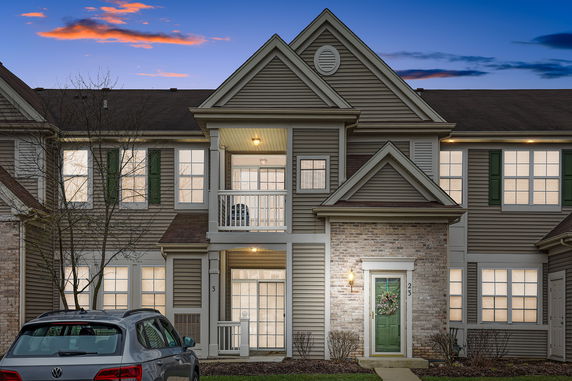 Front view of a two-story townhouse with a balcony and garage.