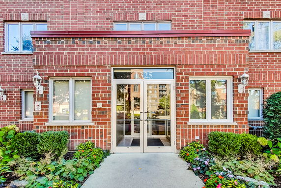 Front view of a building with a brick exterior and glass entrance door.