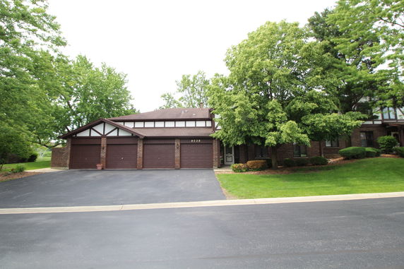 Front view of a house with three-car garage and brick facade.