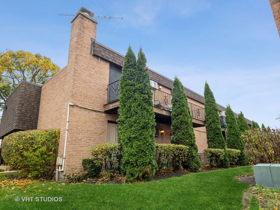 Front view of a multi-story brick building with balconies.